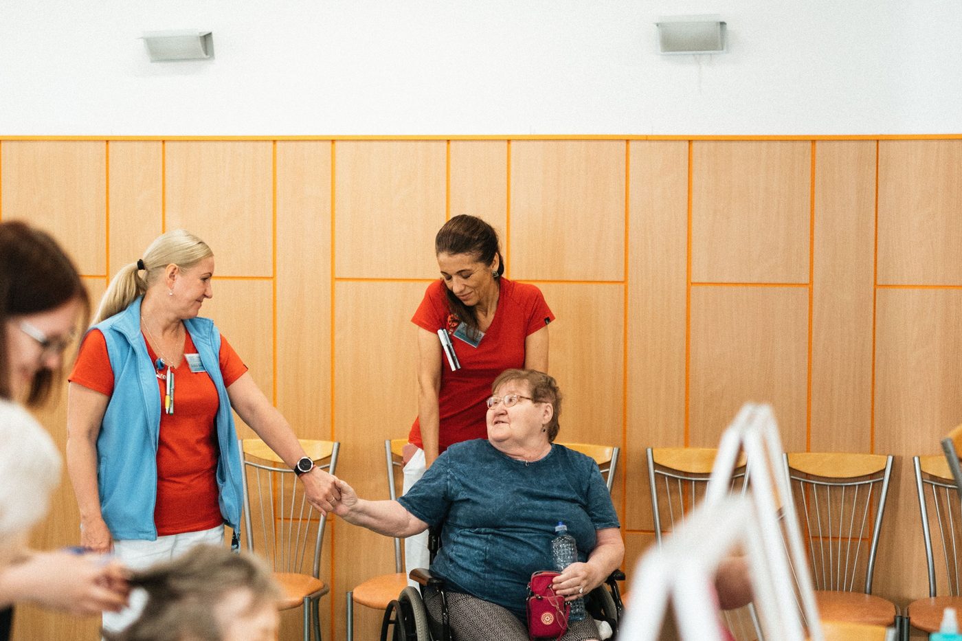 Children and caregivers painting together at easels in a bright activity room.